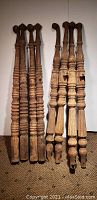Full view of eight antique wooden legs, four paired together on left and right, showing overall size and shape.