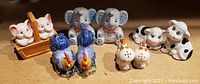 Front view of five sets of vintage animal salt and pepper shakers on display.