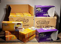 Boxes of six Swiffer WetJet packs with 24 pads each and eleven Swiffer 360 Degree Duster Kits plus one extender box arranged together