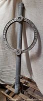 Full view of the City of Toronto bicycle lock stand showing metal post and circular ring with embossed text.