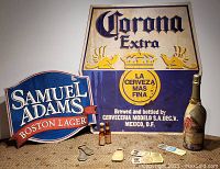 Photo showing the Corona Extra and Samuel Adams tin beer signs, two Corona beer bottle figurines, various bottle openers, and the Millennium Champagne bottle.