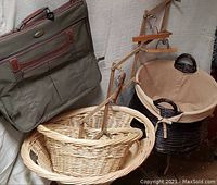Photo showing vintage garment bag, multiple wicker baskets, collapsible wooden hanger, dark wicker hamper with fabric lining and handles.