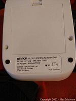 Close-up photo of the Omron Blood Pressure Monitor label showing model BP742N, reference HEM-7131-Z, AC Adapter HEM-ADPTW5, made in Vietnam