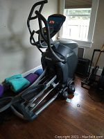 Full view of elliptical cross trainer with attached handlebars and console