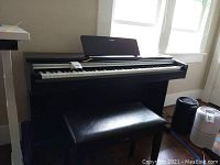 Front view of Yamaha digital piano with bench