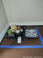 Wide view showing the black tray with candles, stones, jar with bird lid, and the blue and white square dish to the side.