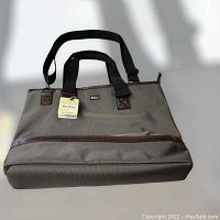 Front view showing grey fabric, black handles, shoulder strap, and original tag with model number PW-20703.