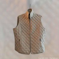 Front view of taupe women's goose down vest with diamond quilting, zippered front and pockets