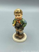 Front view of the colorful vintage Hummel 97 Trumpet Boy figurine showing detailed facial features, clothes, and trumpet.