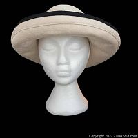 Front view of cream and black hemp hat on styrofoam head with brim flipped upward.