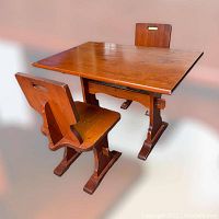 Photo of the pine trestle-style rectangular table with two matching chairs, angled side view showing table surface and chair design.