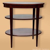 Front view showing oval shape, three tiers, and tapered legs.