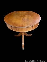 Top view of the round wooden table with some visible scratches and wear on the surface.