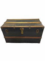 Front view of vintage dark metal and wood trunk showing metal Excelsior lock and wooden slats reinforcement.