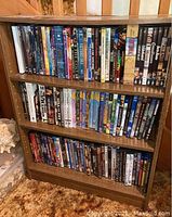 Full view of wooden shelf filled with approximately 75 DVDs