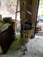 Front view of the full brass valet stand with metal frame showing arms, tray, and base structure.