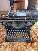 Front view of black enamel Underwood Standard Typewriter on carpet