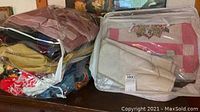 Photo of assorted blankets and quilts in clear plastic bags on a surface