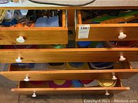 Second photo of drawer contents focused on plastic container lids and some containers