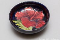 Top view of the bowl showing the red hibiscus flower and green leaf design on a deep blue background.
