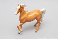 Front-right side view of the glossy ceramic horse figurine showing original green Beswick sticker on the hindquarter.