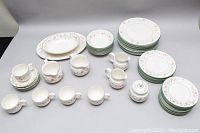 Overview of full dinnerware and serveware set showing plates, bowls, cups, creamers and sugar bowl