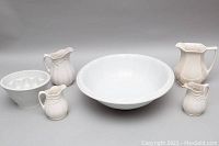 Photo showing entire dish set with large bowl, pitchers, and egg holder dish on white background