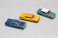 Three vintage metal toy cars including a blue Corgi Chevrolet Impala, yellow Corgi Chevrolet Impala race car with number '01' decals, and a teal green Dinky Triumph 2000 model with white roof. All show age appropriate wear and scratches.