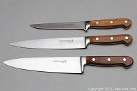 Set of three J.A. Henckels chef knives with wooden handles and visible wear on blades and handles.