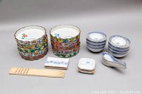 Overview of entire set showing ribbed plates, rice bowls, chopsticks, soup spoons, chopstick rests, and dipping bowls.