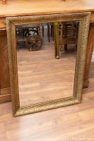 Full front view of mirror leaning against wooden furniture