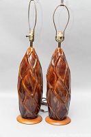 Pair of tall ceramic table lamps with diamond-patterned texture on brown glaze, brass sockets visible, no lampshades present.