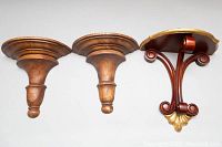 Photo showing all three vintage hand carved wooden wall sconces, including two similar sconces with broad flat tops and one decorative ornate sconce with scrollwork and gold accents.