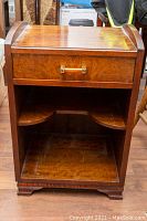 Front view of the wooden side table showing drawer with handle and open bottom shelf with curved sides.