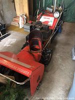 Front and side view of Yard-Man Snowbird snowblower showing chute and handlebar controls