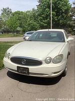 Front view of white sedan showing Buick grille and emblem