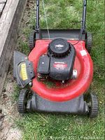 Top view of the red Yard Machines push mower showing the Briggs & Stratton engine and mower deck with side discharge chute.
