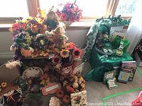 Wide view showing combined fall and St. Patrick's Day decorations arranged by window including flowers, figurines, pumpkins, leaf garland, and baskets.