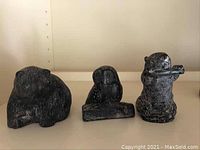 Front view of three soapstone animal carvings: a bear, an owl, and a beaver.