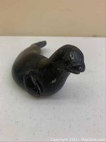 Front side view of black seal carving showing head and front flippers