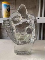 Side view of the clear textured ice glass sculpture showing organic abstract form and thick base.