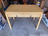 Front view of bamboo finish desk showing drawer and brass-tone pulls