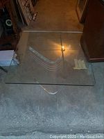 Photo showing the square clear glass tabletop and Lucite base from above.