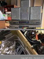 Front view of amplifier, cassette deck, CD player stacked with center channel and rear Technics speakers on top and cables visible below.