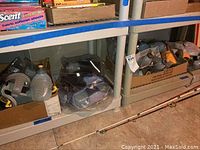 Boxes containing multiple Runner brand translucent water bottles with yellow caps and grey waist band carriers on a shelf.