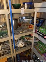 Large parfait serving dish, metal ice bucket, ceramic bowls, and decorative wooden signs on metal shelving