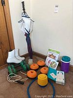 Photo showing women's figure skates size 9, hand weights, exercise pump parts, umbrella, DVDs and Fitbit related items.