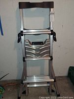 Front view of folded Little Giant SmartStep aluminum ladder showing black top cap and foldable steps.