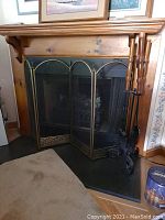 Fireplace screen set up in front of fireplace with tools hanging on iron stand
