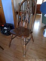 Single wooden spindle back chair showing overall shape and design.